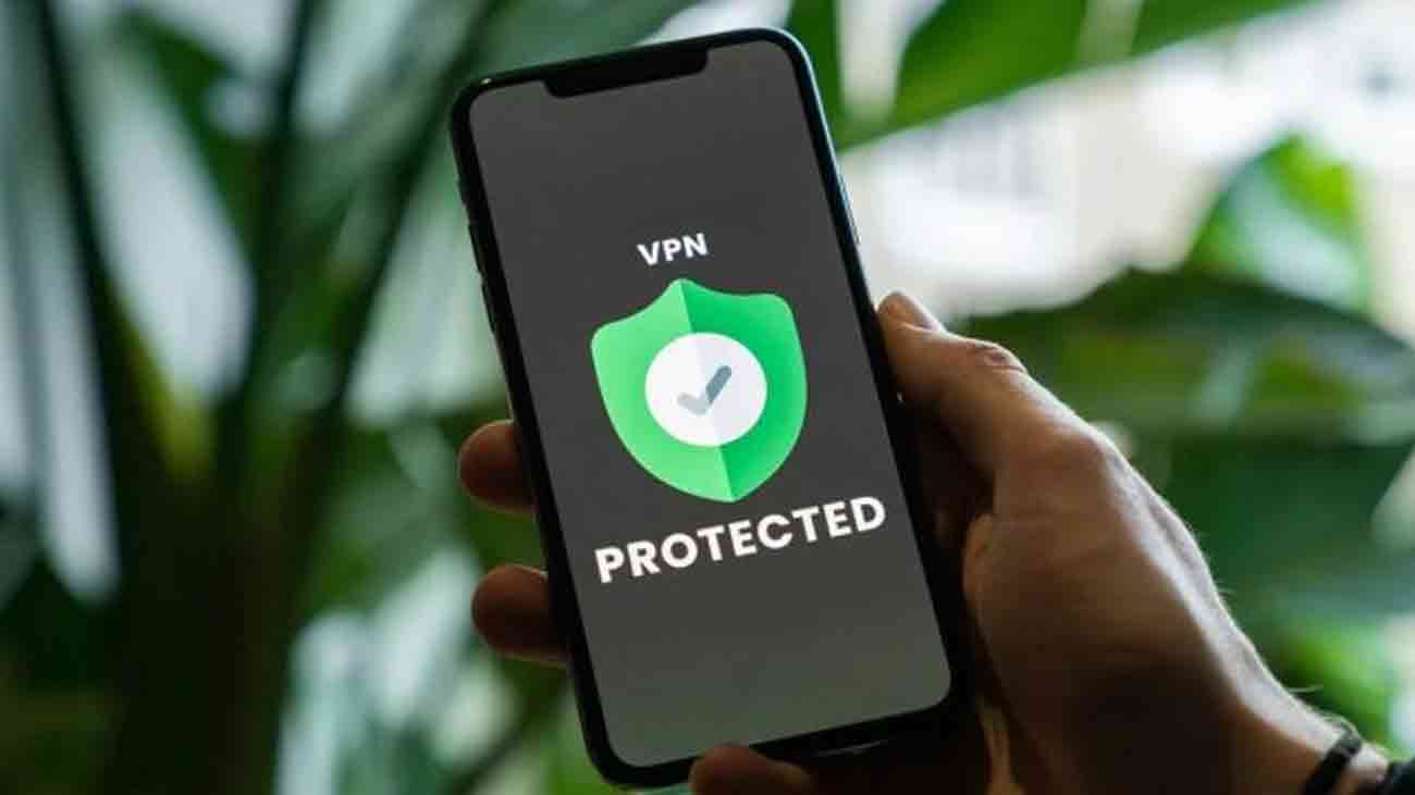 A person is holding a mobile in his hand while VPN is visible on his screen.