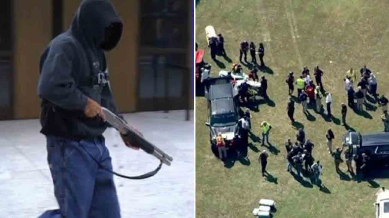 The American school shooting student is standing with a gun in his hand while police cars are parked on the other side.