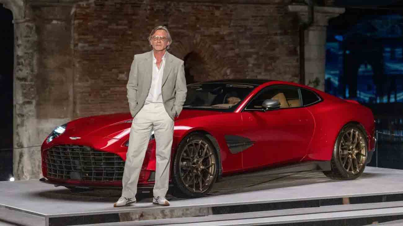 Hollywood star Daniel Craig, famous for his role as James Bond, stands in front of the new red car of the Aston Martin company.